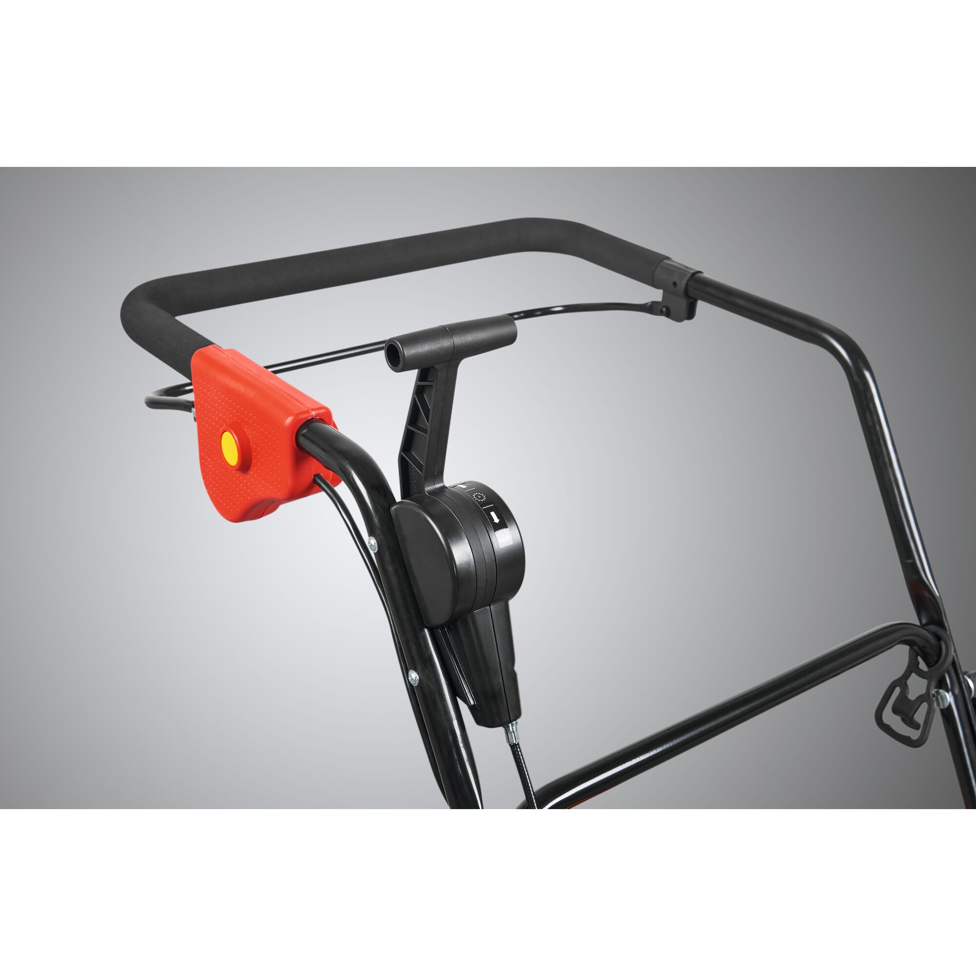 Close-up view of a lawn mower handle with a red and yellow safety switch and a black control lever, against a neutral background.