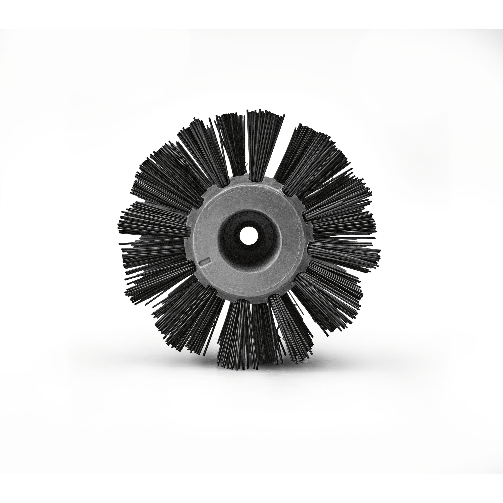 A close-up image of a cylindrical brush head with stiff black bristles and a central mounting hole, designed for use with cleaning or garden maintenance equipment.