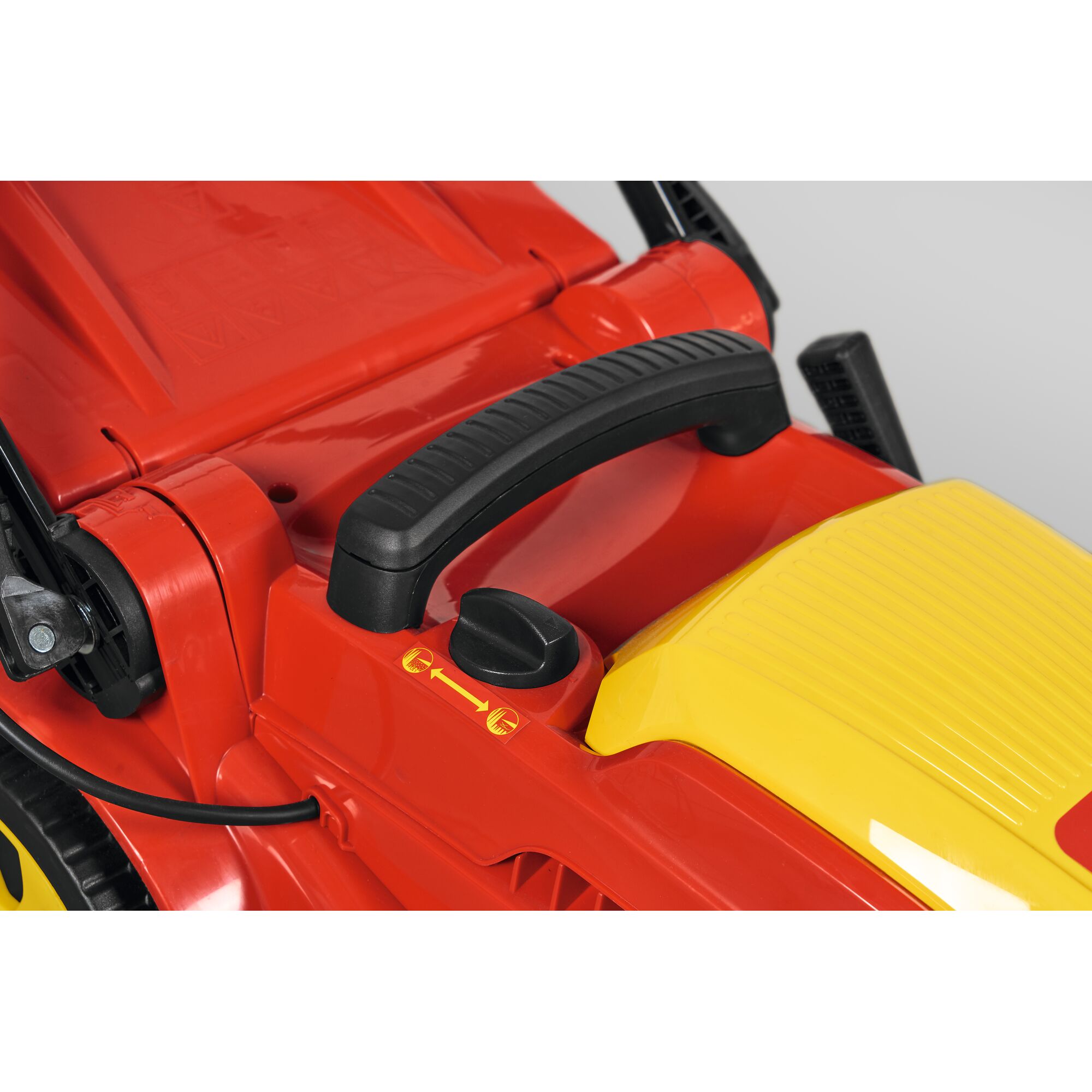 Close-up view of the handle and control knob of a red and yellow lawn mower, showing detailed components and adjustment markings.