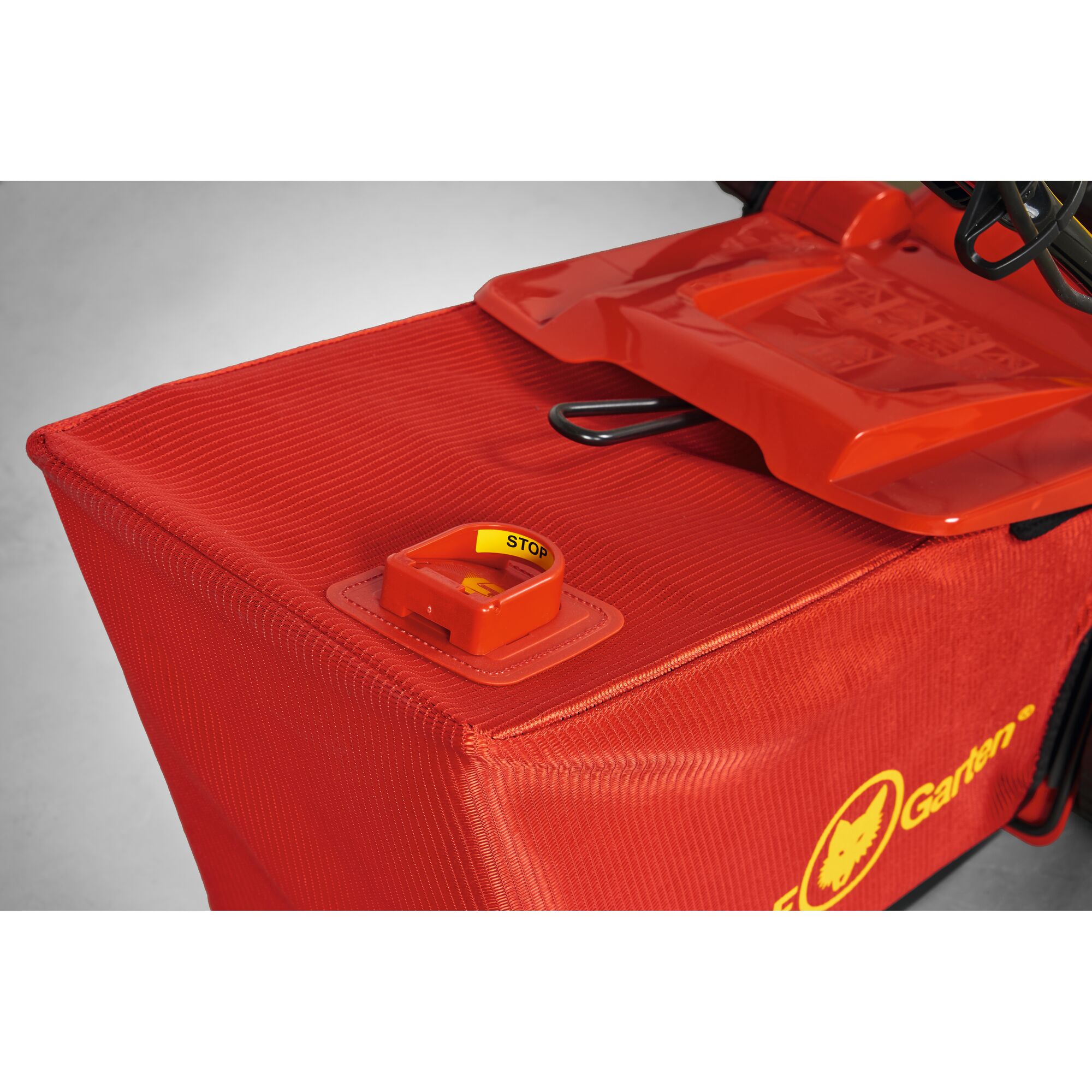 Close-up of a red WOLFGarten garden machine with a yellow stop indicator on top.