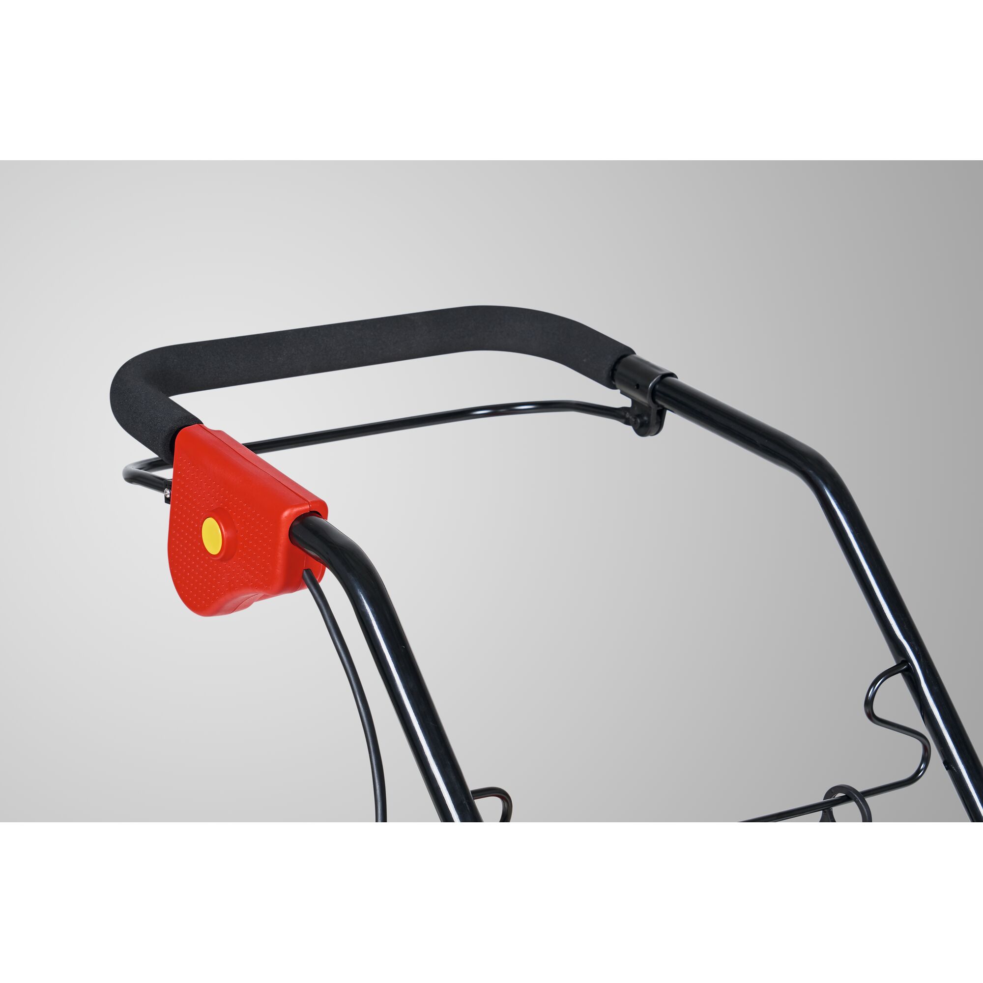 Close-up of the handlebar of a garden tool, featuring a black foam grip and a red plastic connector with a yellow button.