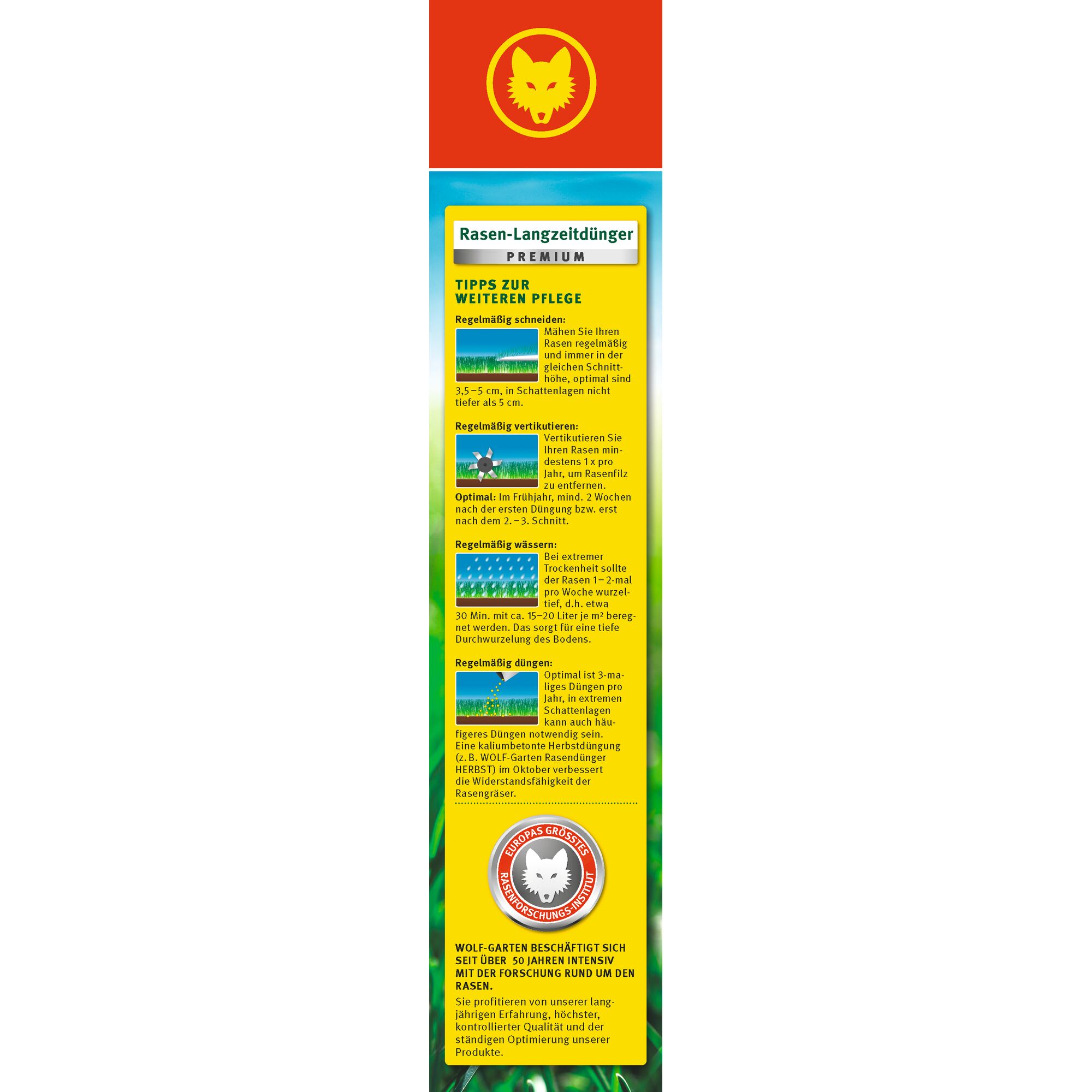 Vertical image of a WOLFGarten Rasen-Langzeitdünger Premium lawn fertilizer package, featuring a red section at the top with a yellow wolf head logo. Below, the package displays textual tips for lawn care in German, including sections about mowing, aerating, watering, and fertilizing, illustrated with small icons. At the bottom, there is a seal with the wolf logo and additional product and company information.