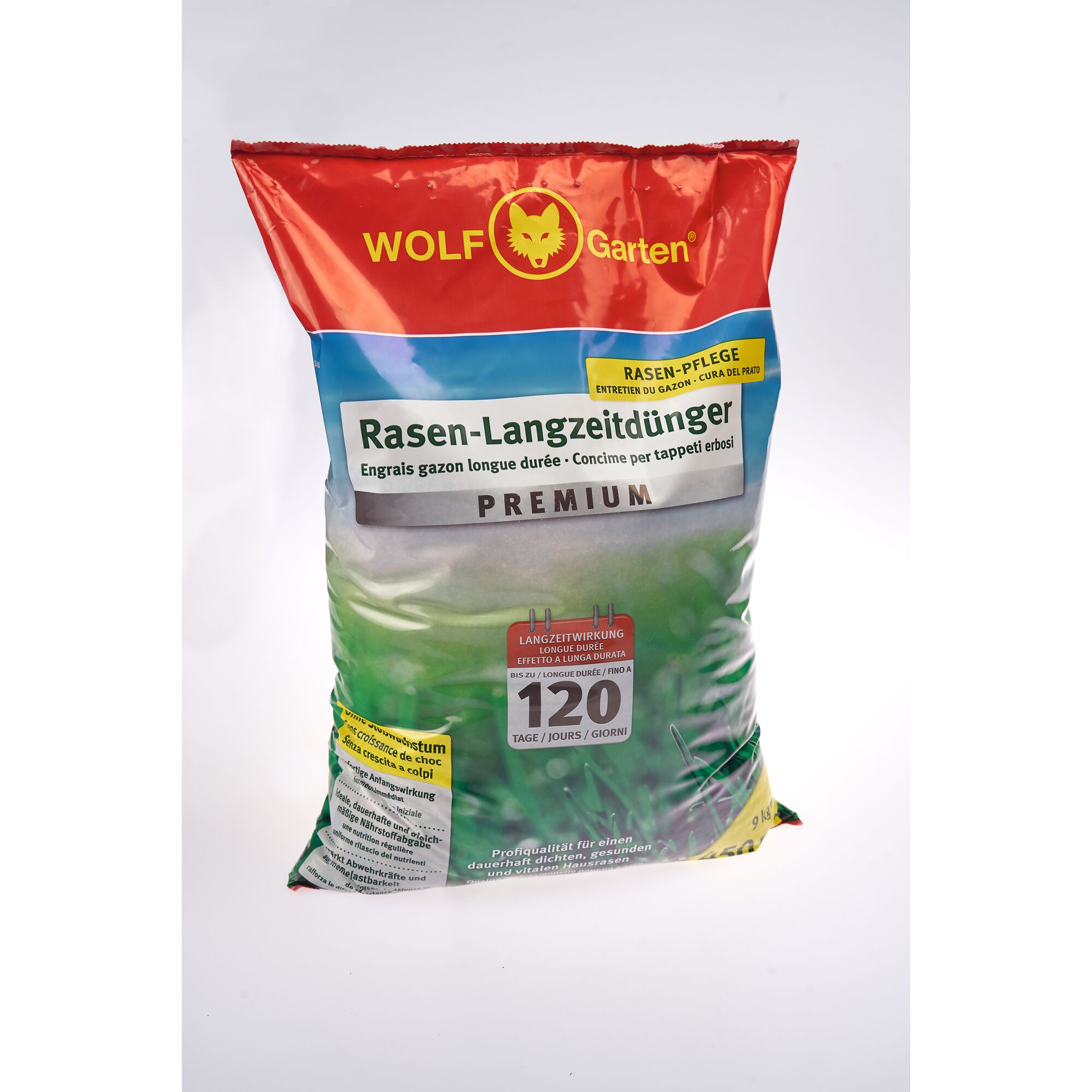 A bag of WOLF Garten Premium lawn long-lasting fertilizer, labeled in multiple languages. The packaging is red and blue with green grass imagery and highlights 120 days of effectiveness.