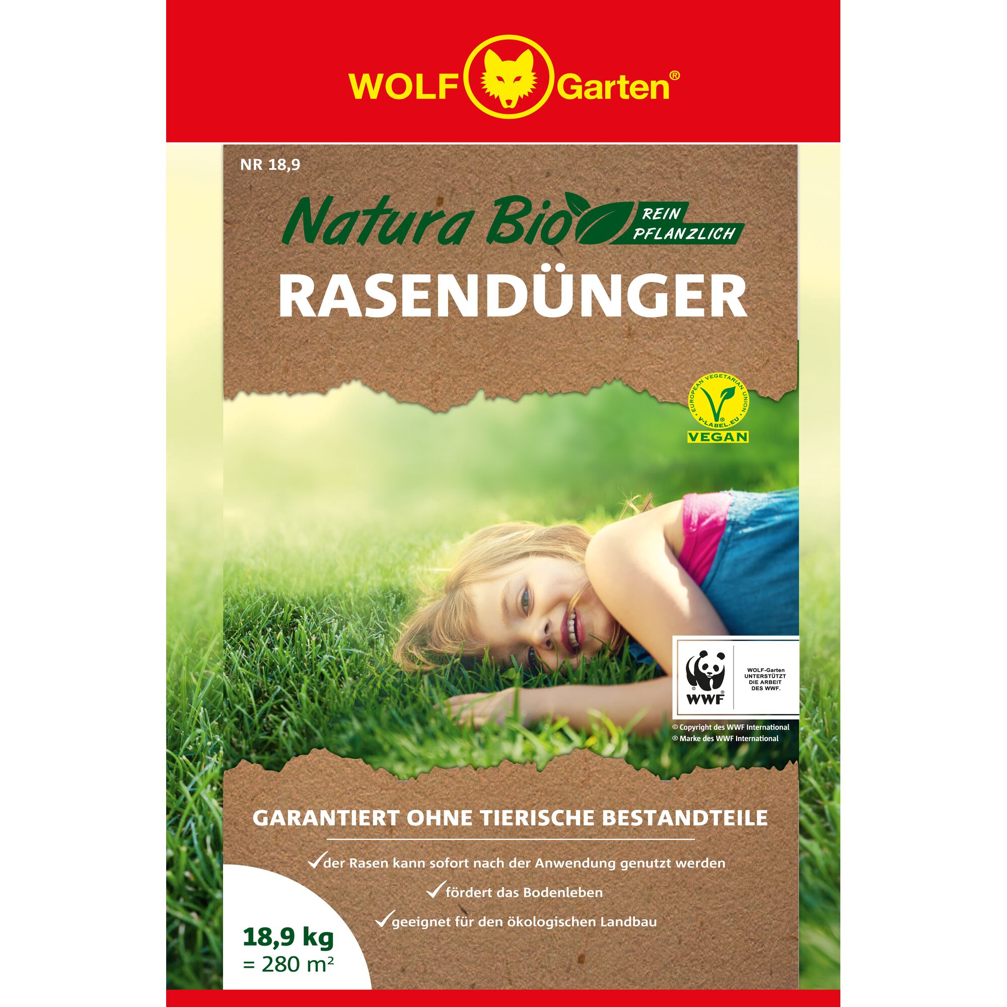 Front packaging of WOLF Garten Natura Bio lawn fertilizer, featuring a red and brown design with a logo at the top. The text highlights that it is vegan and purely plant-based, with no animal components, suitable for organic farming. It includes certification logos and an image of a person lying on green grass.