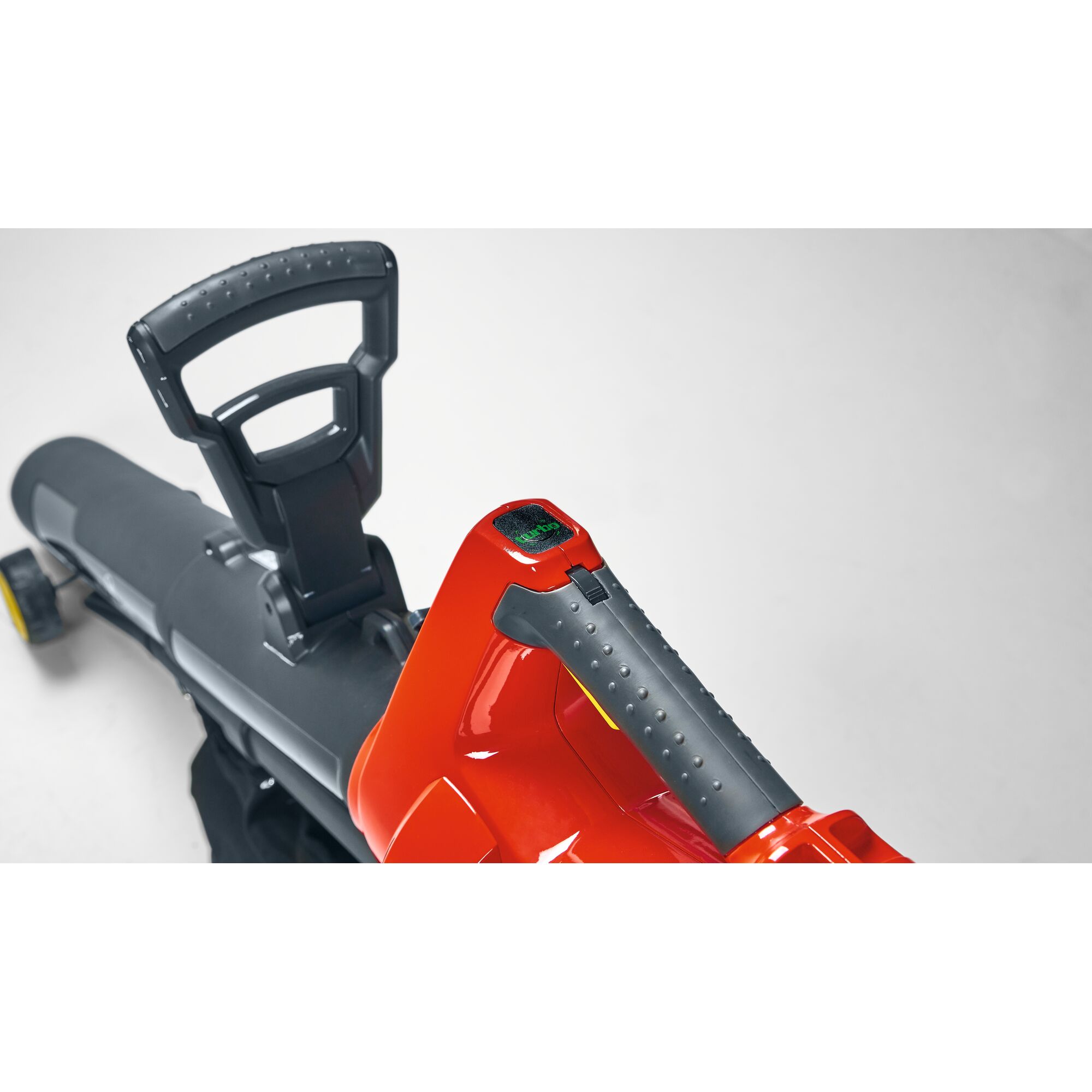 Close-up view of a WOLFGarten outdoor garden tool featuring a black and red handle, textured grip, and control buttons.