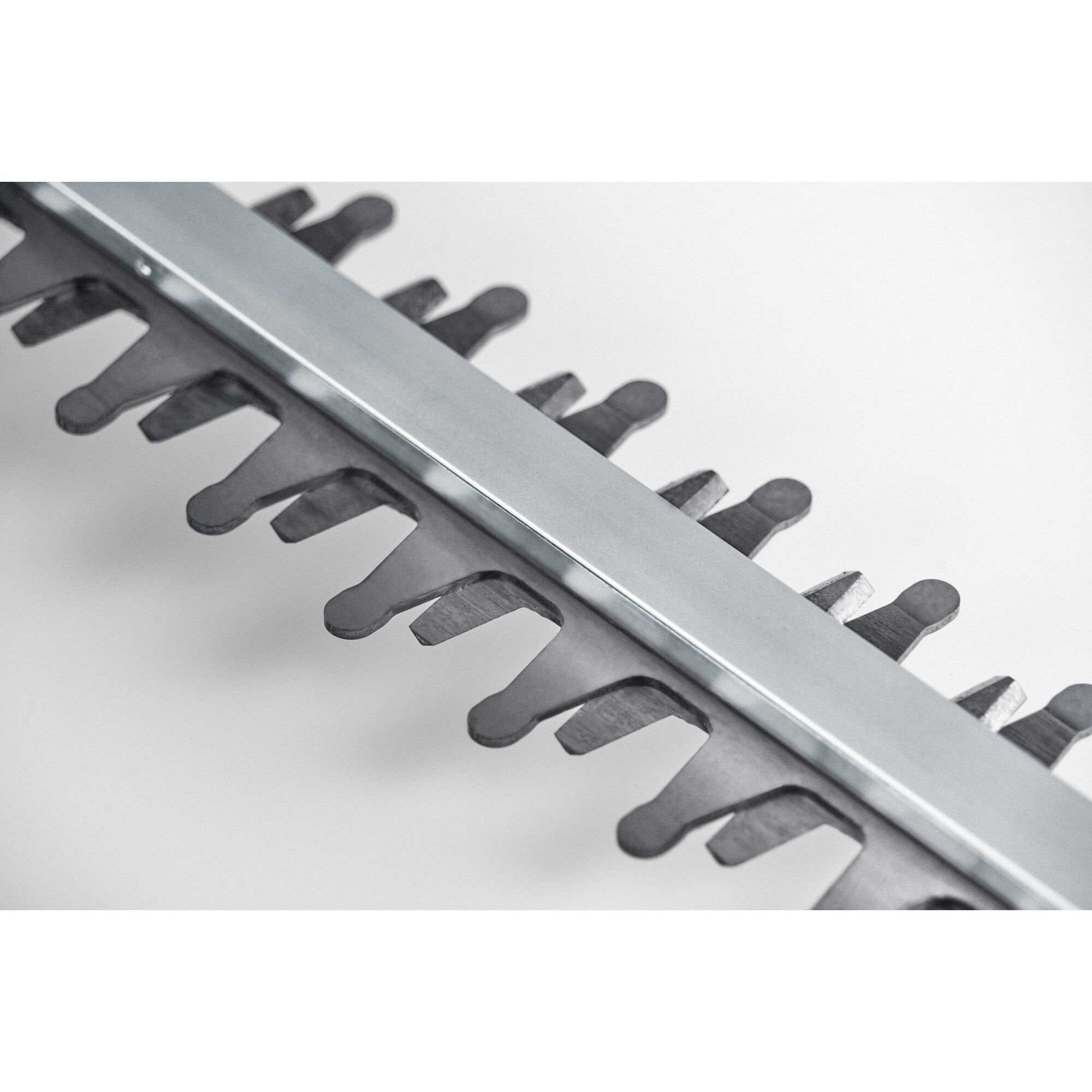 Close-up view of a metal hedge trimmer blade, showing the sharp teeth against a white background.