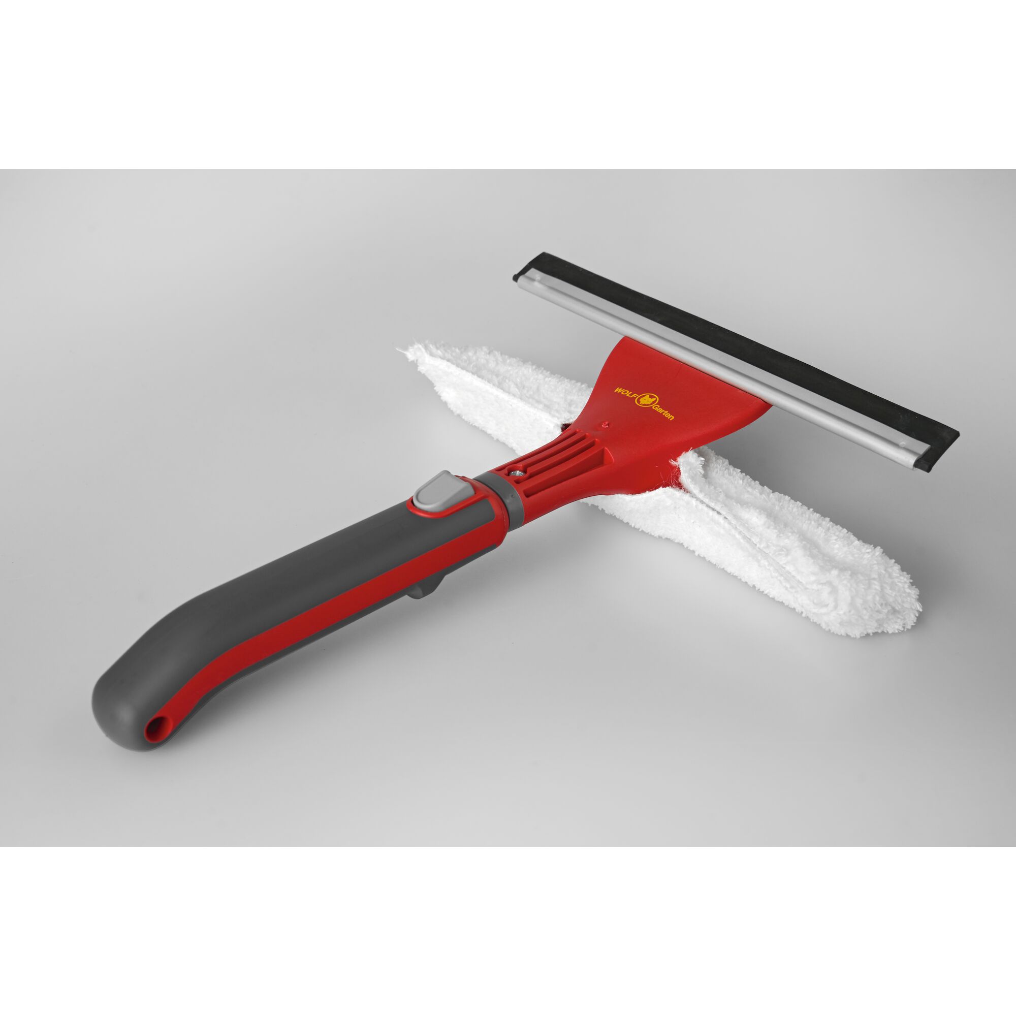 Red and grey WOLFGarten window cleaning tool with a rubber squeegee and a white microfiber pad, placed on a light grey background.