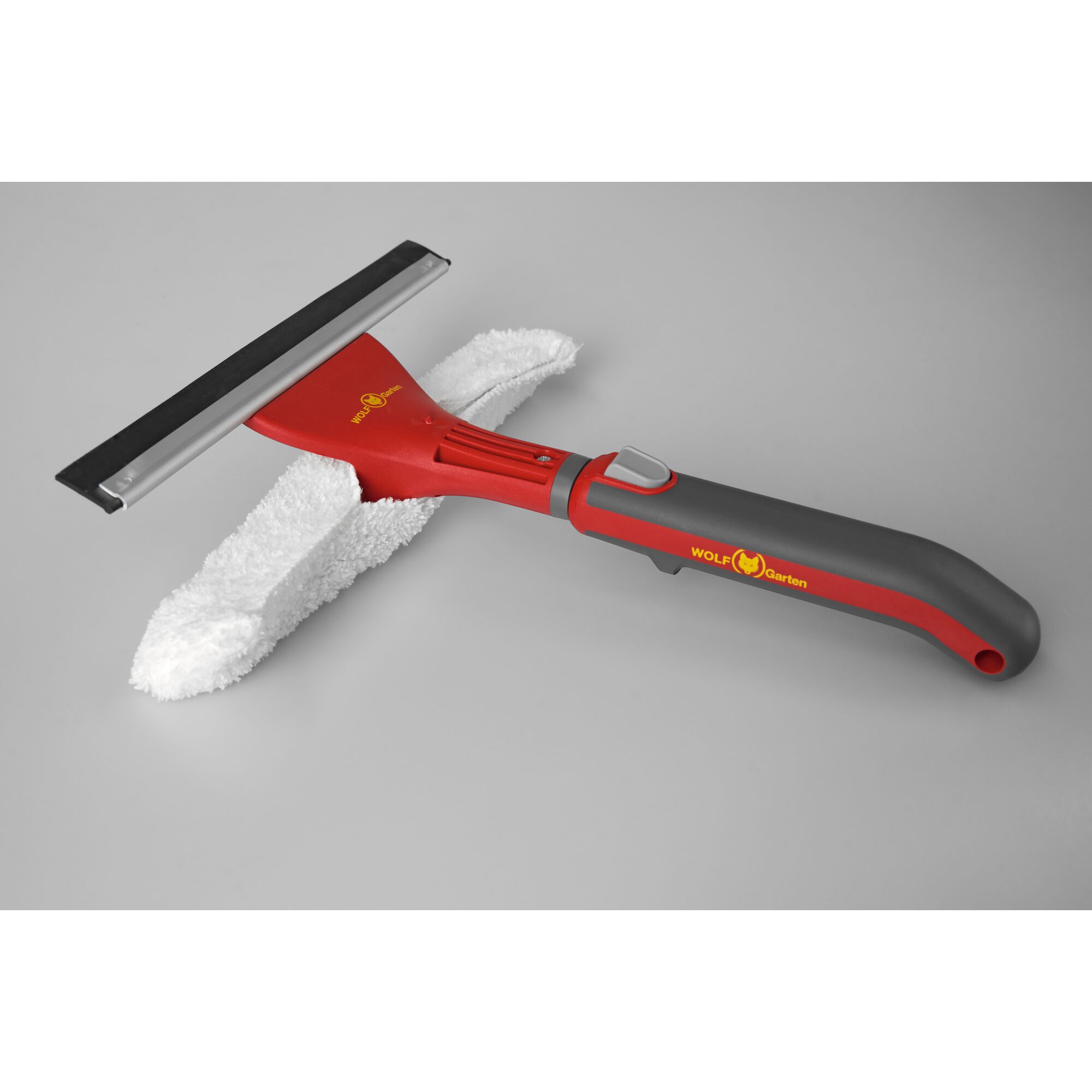 A WOLF Garten window cleaning tool with a red and grey handle, a black rubber squeegee, and a white microfiber pad on a light grey background.