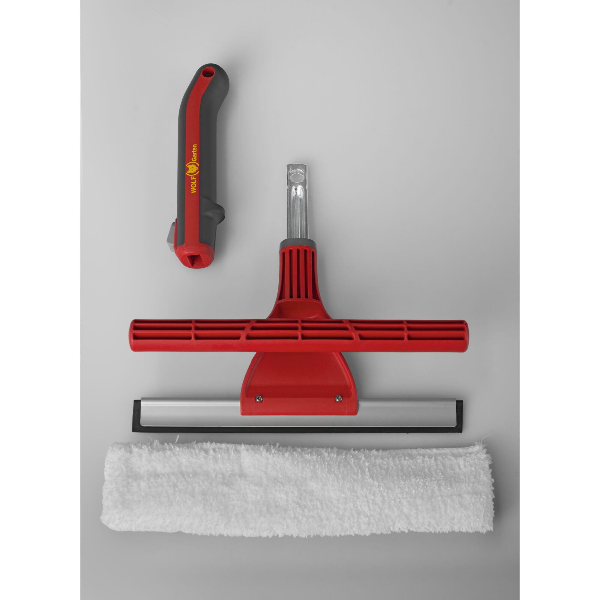 A WOLFGarten window cleaning kit consisting of a red and grey ergonomic handle, a red and silver squeegee, and a white microfiber cleaning cloth, arranged on a light gray background.
