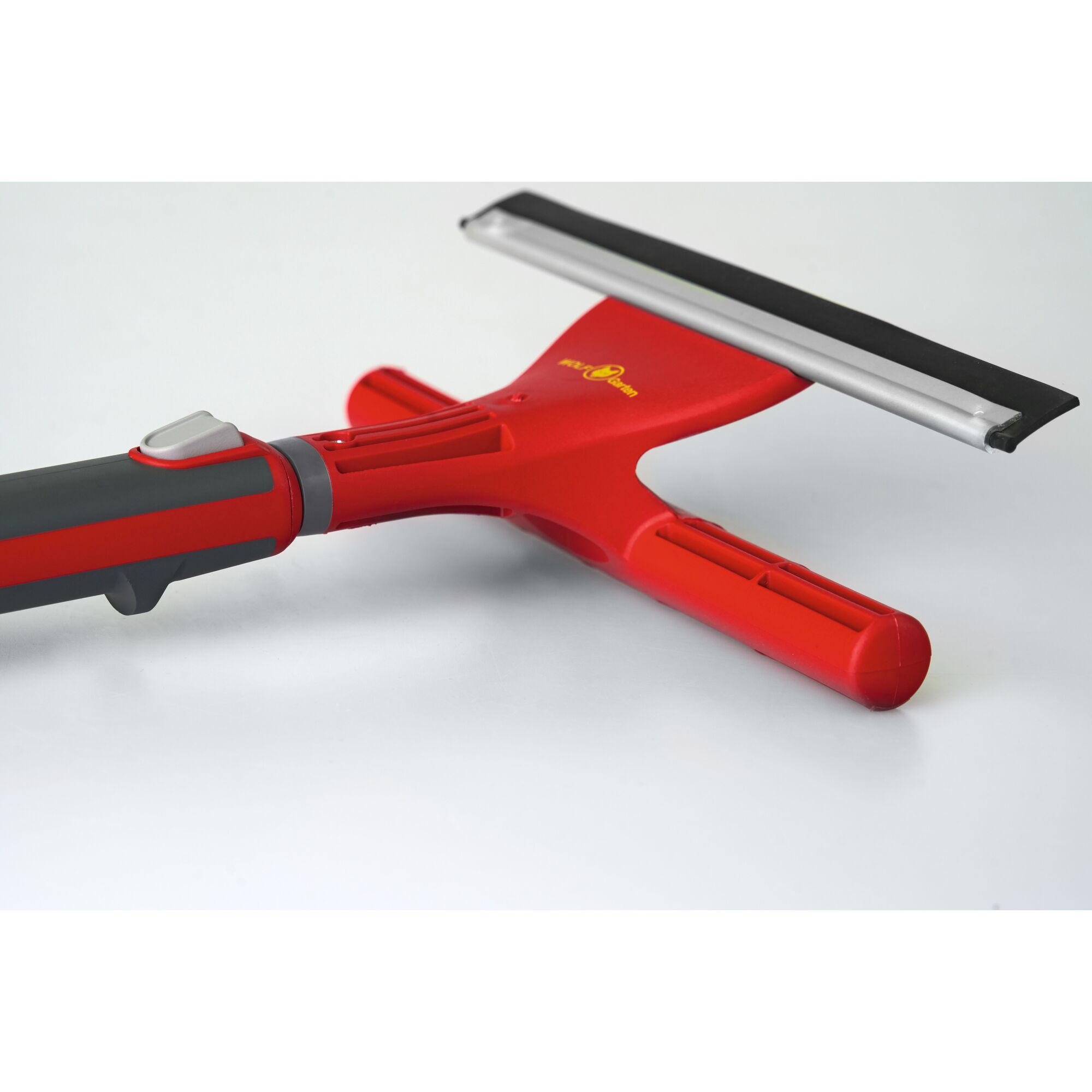 A close-up image of a red and black window squeegee tool with a rubber blade, placed on a white surface.