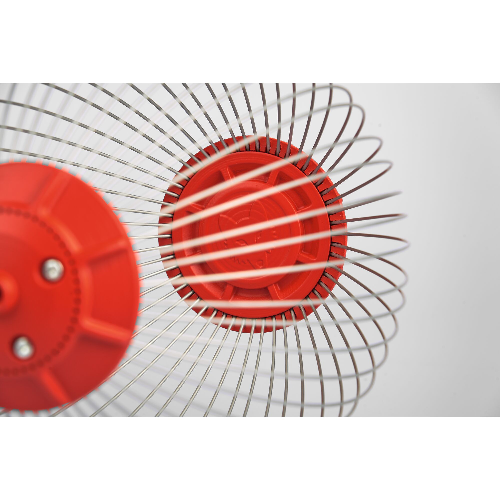 Close-up view of a WOLFGarten gardening tool featuring metal wire basket sections with red plastic hubs, photographed against a white background.