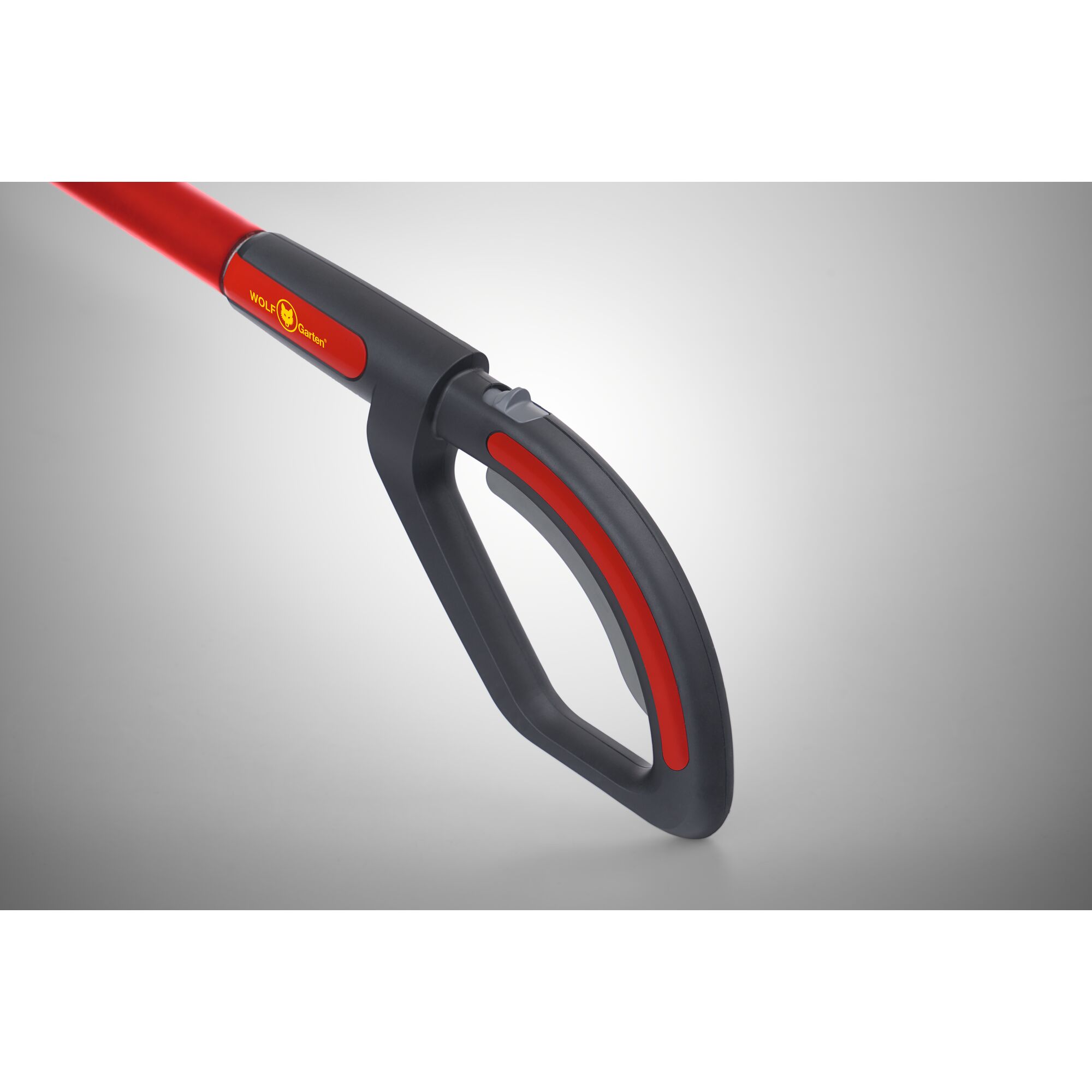 Close-up of the handle of a WOLFGarten gardening tool, featuring a black and red ergonomic grip.