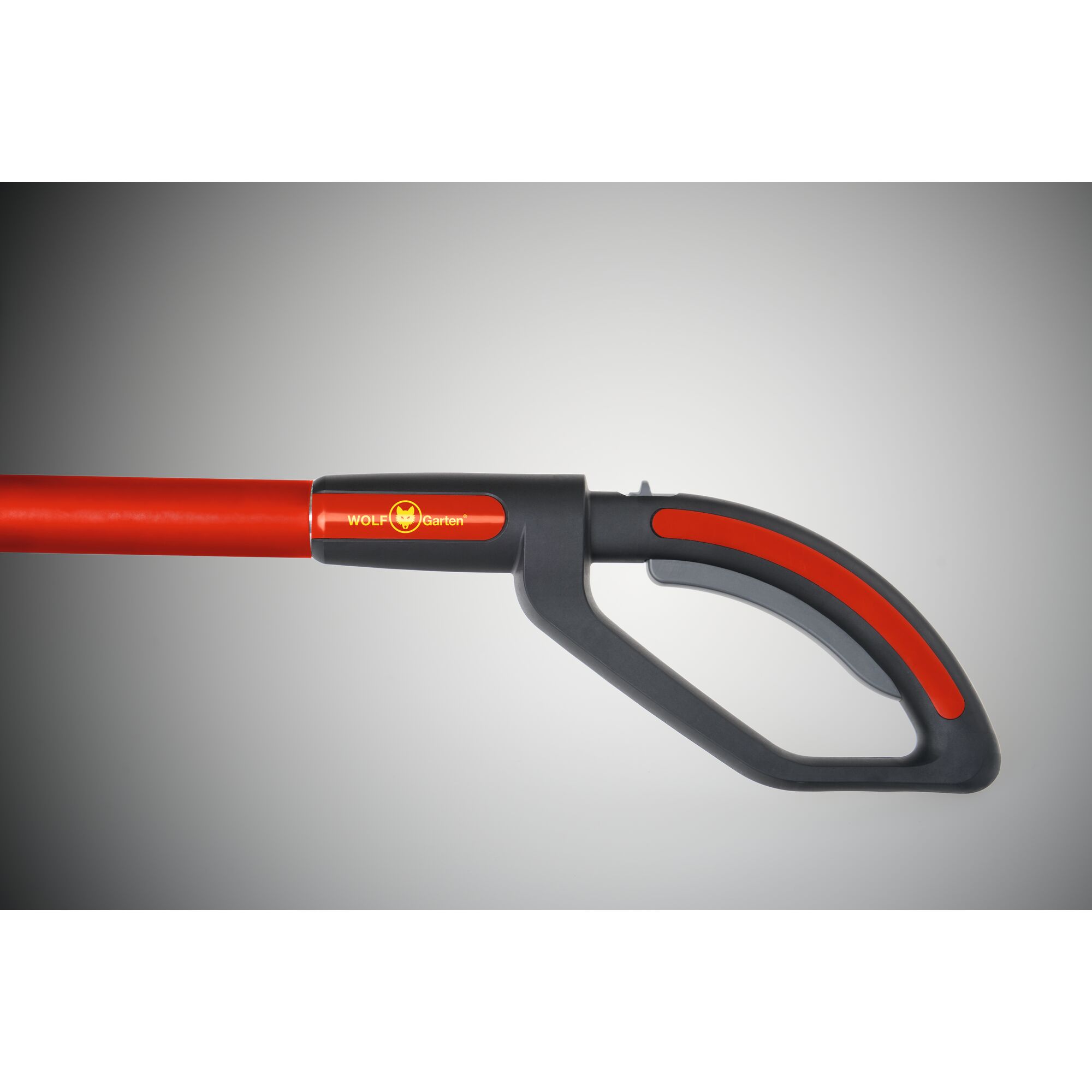 A close-up of a WOLF-Garten gardening tool handle, featuring a black and red ergonomic grip with the WOLF-Garten logo visible on the shaft.