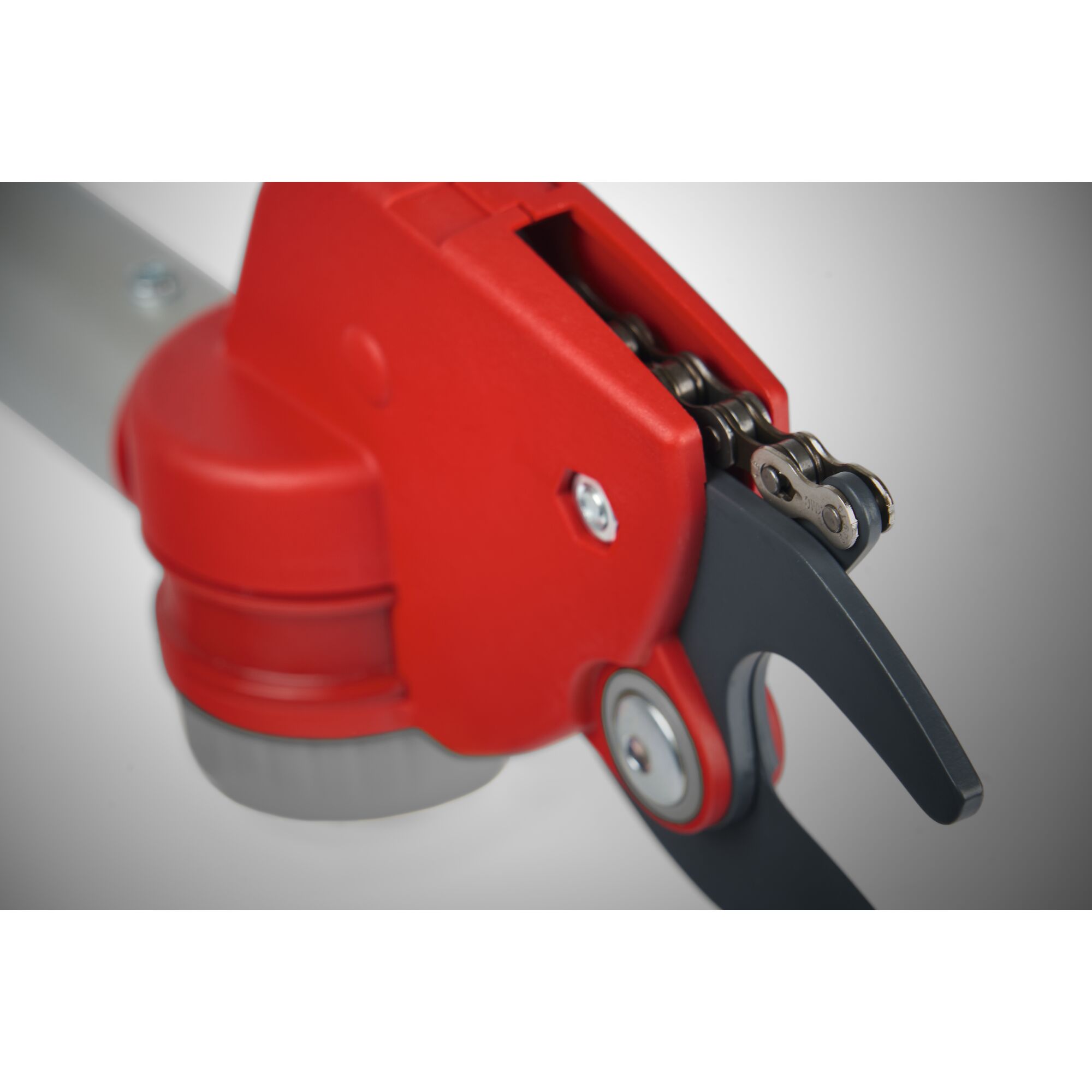 Close-up view of the mechanism on a WOLFGarten garden tool with a red housing and metal cutting blade.