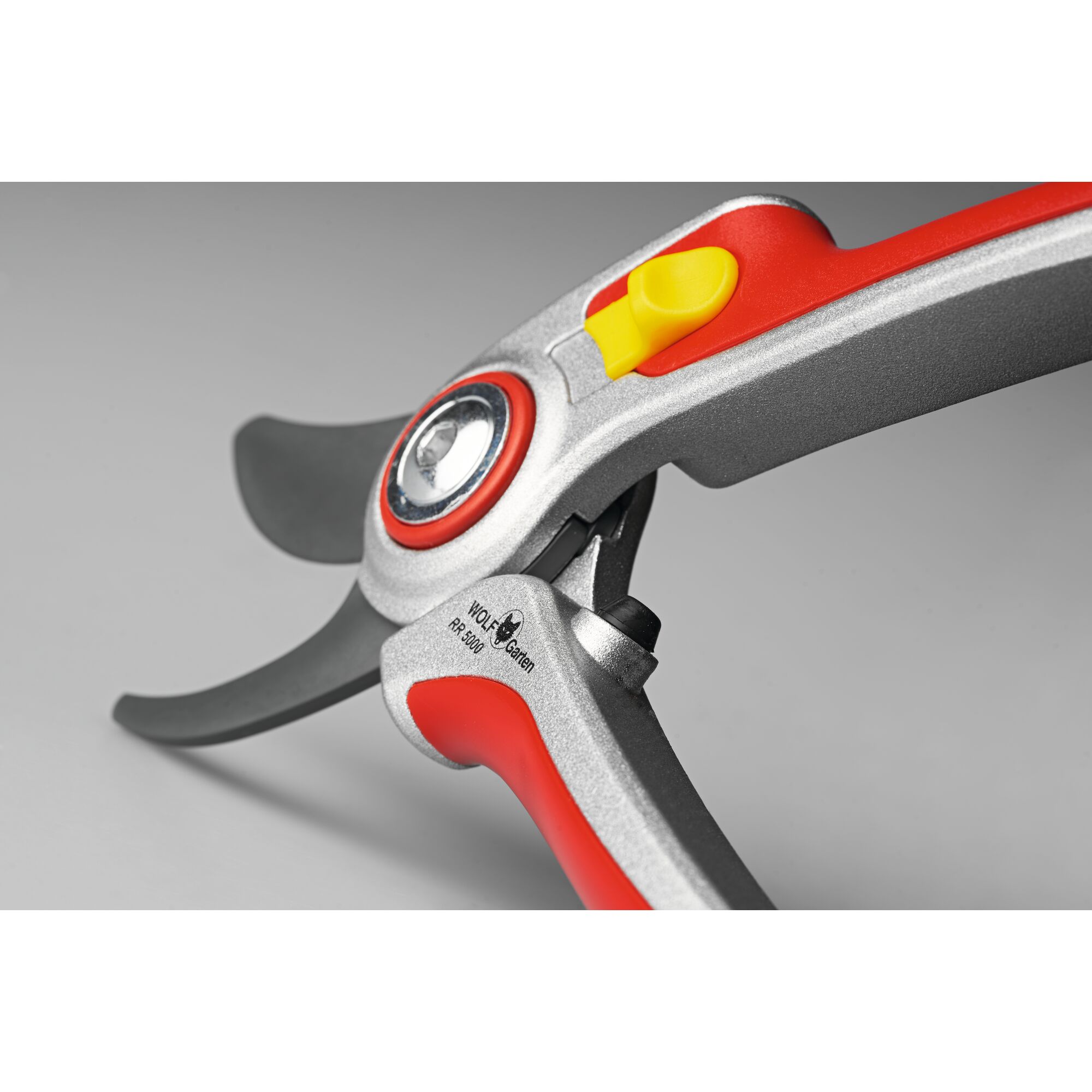 Close-up view of a WOLFGarten garden pruning shear with silver metallic handles, red accents, and a yellow safety lock, photographed on a neutral background.