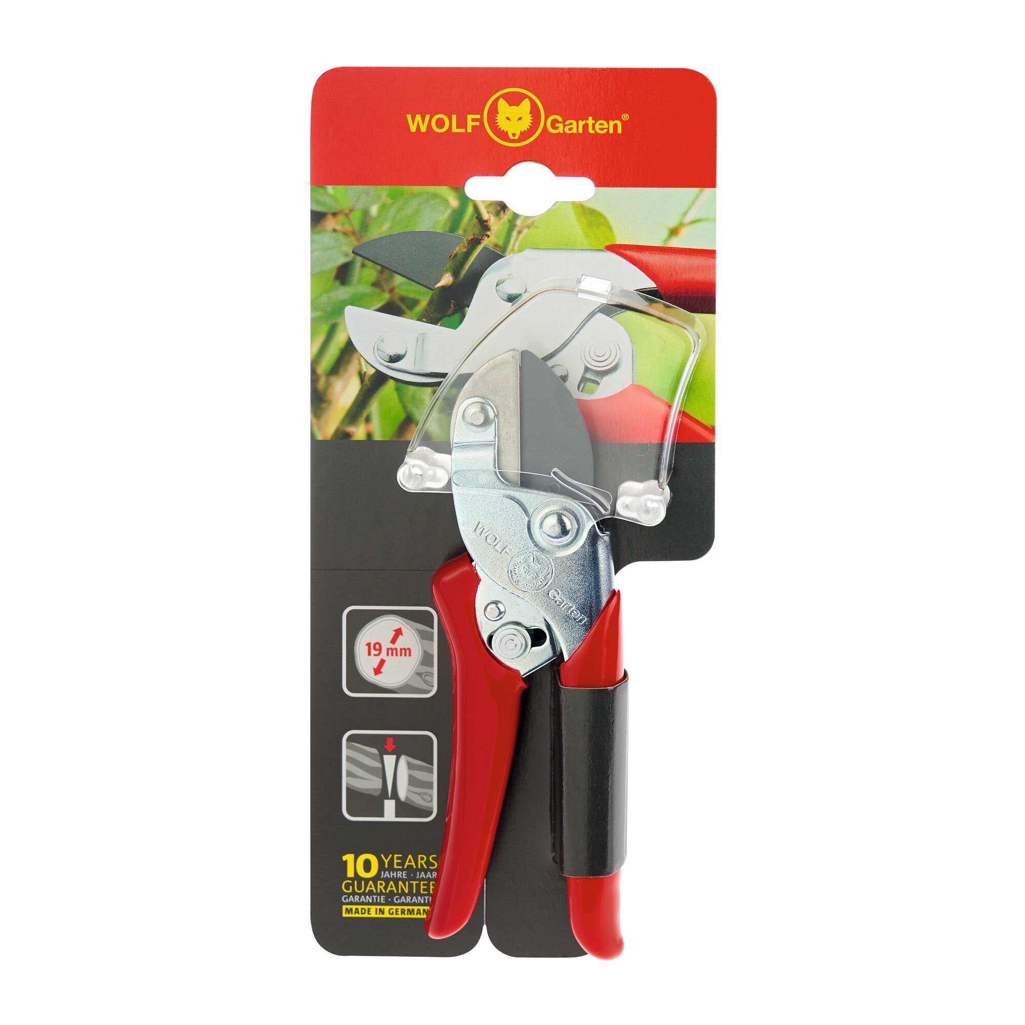 WOLF Garten pruning shears in packaging, featuring red handles and a metal blade. The packaging includes product information such as 19 mm cutting diameter, a ten-year guarantee, and illustrations of usage. The background shows a plant branch being cut.