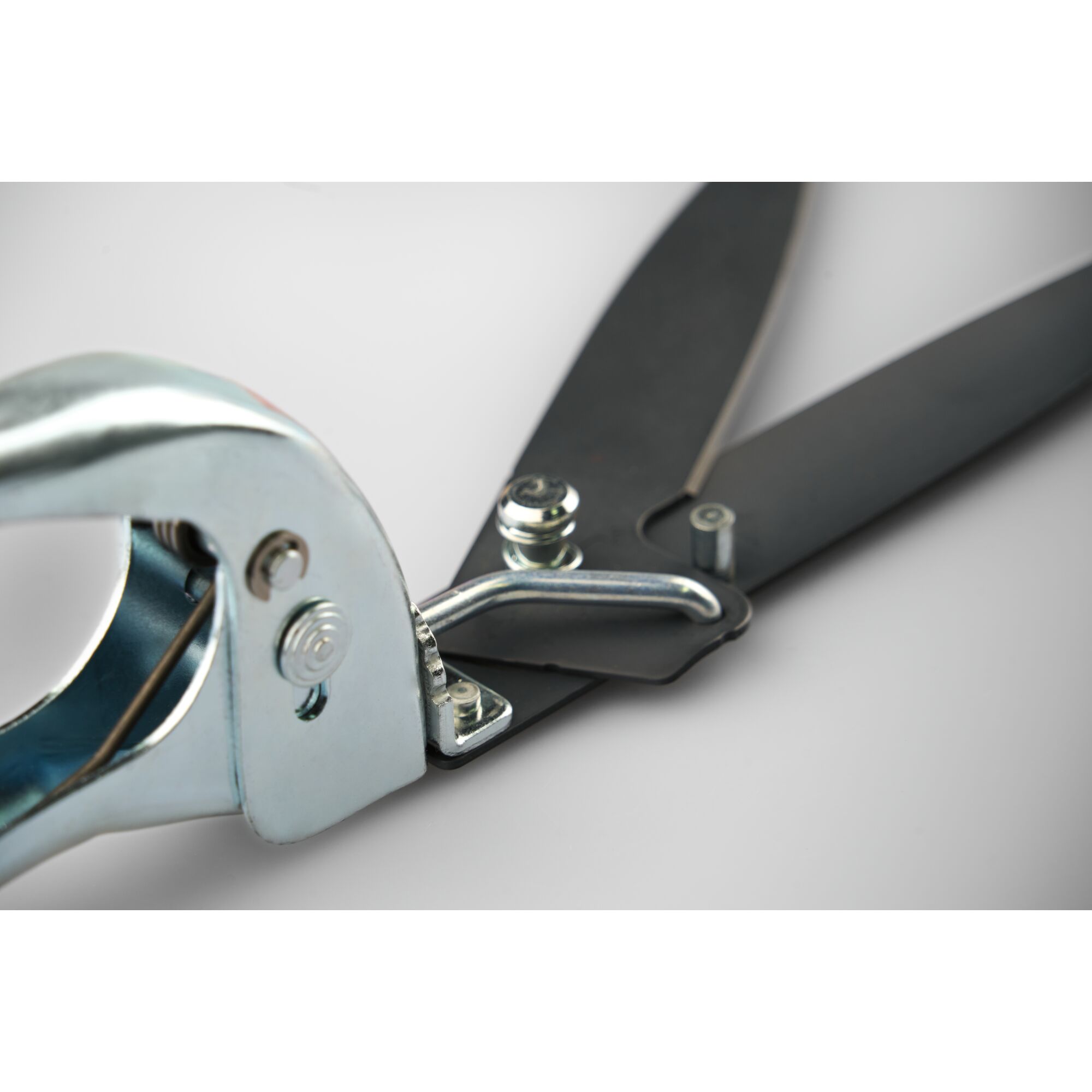 Close-up view of a metal garden shear with black blades, showcasing the handle and blade joint on a neutral background.