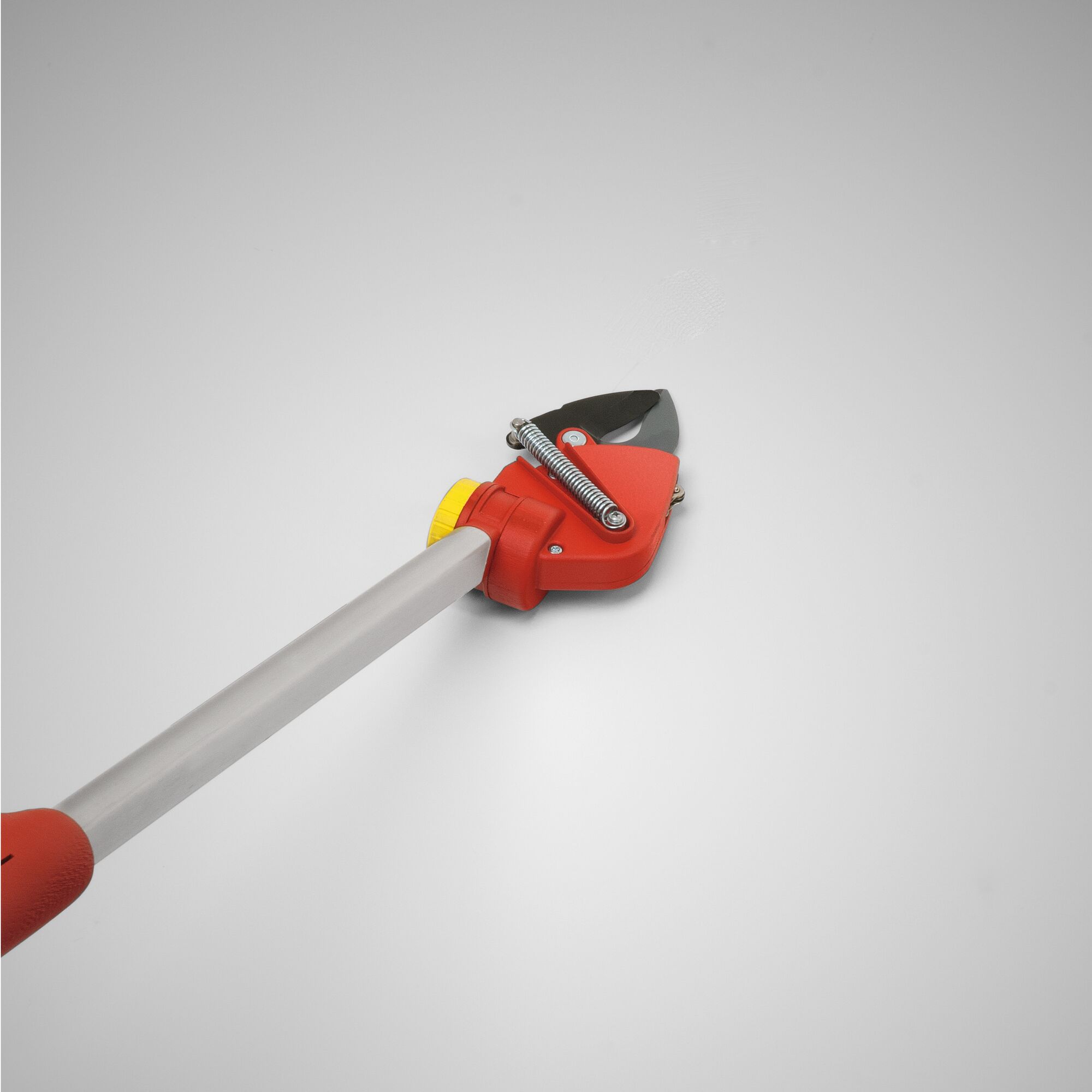 Close-up of a WOLF-Garten long-reach pruner with a red cutting head, silver blade, yellow adjustment knob, and gray handle, shown on a plain background.